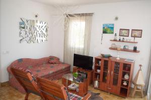 a living room with a couch and a television at Apartment Ela - very close to beach in Rogač