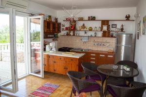 a kitchen with a refrigerator and a table with chairs at Apartment Ela - very close to beach in Rogač