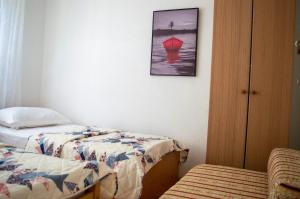 a bedroom with two beds and a picture on the wall at Apartment Ela - very close to beach in Rogač