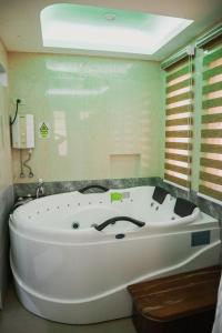 La salle de bains est pourvue d'une grande baignoire blanche. dans l'établissement Youhan Beach Resort, à San Antonio