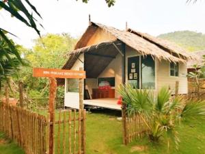 Koh Phaluai beach cottage في Koh Phaluai: منزل صغير وامامه لافته