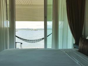 a bedroom with a bed and a view of the ocean at Satun Sea Balcony ระเบียงเล 