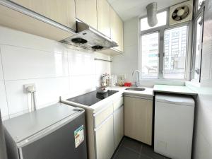 a white kitchen with a sink and a dishwasher at MK高雅公寓2房1厅一卫4 to 6人油麻地地鐵口一分鐘 香港主街道彌敦道正街 in Hong Kong