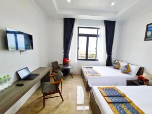 ein Hotelzimmer mit 2 Betten und einem Schreibtisch in der Unterkunft Seaside Hotel - Rach Gia in Rạch Giá