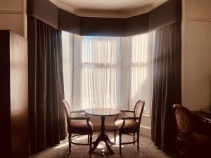 a table and chairs in a room with a window at The Lovat Hotel in Perth