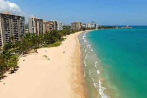 an aerial view of a beach with buildings and the ocean at private apartmento airport 7 minutes y de la playa in Carolina