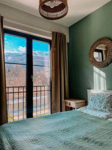 ein Schlafzimmer mit einem Bett und einem großen Fenster in der Unterkunft Vitosha View Apartment & Free Parking in Sofia