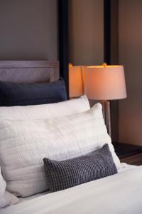 un primo piano di due letti con lenzuola bianche e una lampada di Condesa Luxury Lofts 1510 a Città del Messico Altre 18 foto