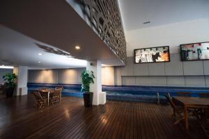 una sala da pranzo con tavoli e sedie e una TV di Condesa Luxury Lofts 1510 a Città del Messico