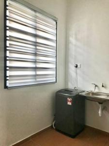 La salle de bains est pourvue d'un lavabo et d'une grande fenêtre. dans l'établissement Cikgu I&S Homestay, à Jitra