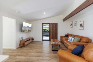 een woonkamer met een bank en een tafel bij Fiery, cozy starry nights - Farm stay! in Bellthorpe +51 foto's