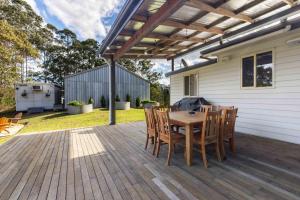 a wooden deck with a wooden table and chairs at Fiery, cozy starry nights - Farm stay! in Bellthorpe