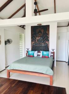 1 dormitorio con 1 cama con una pintura en la pared en Banana Villa Koh Tao en Ko Tao