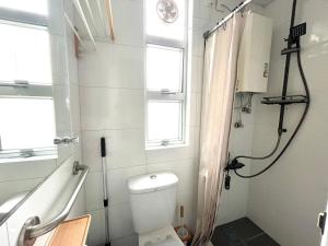 a small bathroom with a toilet and a shower at MK高雅公寓2房1厅一卫4 to 6人油麻地地鐵口一分鐘 香港主街道彌敦道正街 in Hong Kong