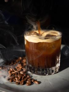 a cup of coffee sitting on top of a pile of coffee beans at Mesón De Leyendas Breakfast & Downtown in Valle de Bravo