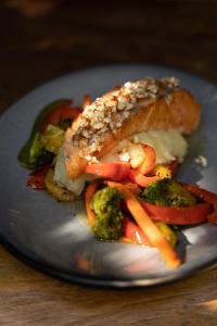 un plato de comida con un trozo de pescado y verduras en Mesón De Leyendas Breakfast & Downtown en Valle de Bravo