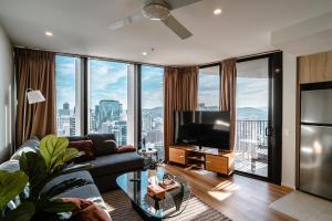 uma sala de estar com um sofá e uma televisão de ecrã plano em Lux 37th floor 2br 2bath, Infinity pool, Gym, Wifi em Brisbane