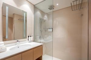 La salle de bains est pourvue d'un lavabo et d'une douche. dans l'établissement Holiday Inn & Suites - Dubai Science Park, an IHG Hotel, à Dubaï