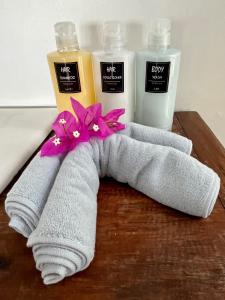 une serviette avec des fleurs dessus à côté de deux bouteilles de savon dans l'établissement Banana Villa Koh Tao, à Koh Tao