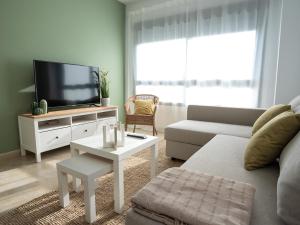 a living room with a couch and a tv at Apartamentos Brisas del Puerto de Aguadulce in Aguadulce