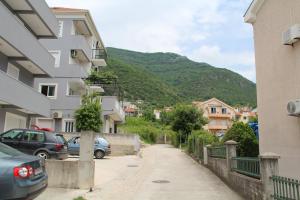 eine Stadtstraße mit Gebäuden und einem Berg in der Unterkunft Luna Portonovi apartments in Herceg-Novi