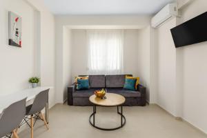 - un salon avec un canapé et une table dans l'établissement V Luxury Apartments with Pool, à Siviri