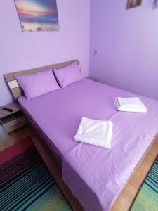 コンスタンツァにあるApartament Aurelianの紫色のベッド1台(タオル2枚付)
