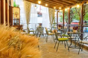 un patio con mesas, sillas y plantas en Hotel Theopisti, en Ouranoupoli