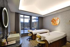 ein Krankenhauszimmer mit 2 Betten und einem Fenster in der Unterkunft Vance Hotel - Taizhou in Taizhou