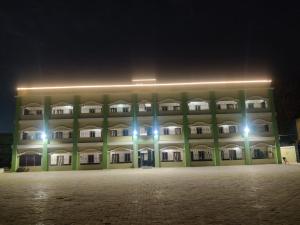 a large building with lights in front of it at night at Heritage Bagala Dharmasala in Puri