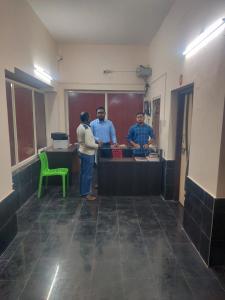 a group of three people standing in a kitchen at Heritage Bagala Dharmasala in Puri