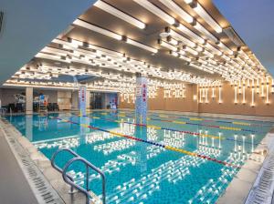 a large swimming pool in a building with lights at Vance Hotel - Taizhou in Taizhou