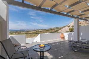 a view from the balcony of a house with a table and chairs at Sunset Village 4 in Paleochori +8 photos