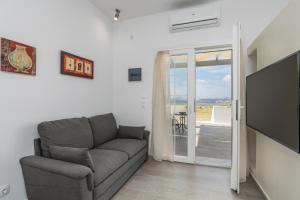 a living room with a couch and a flat screen tv at Sunset Village 4 in Paleochori