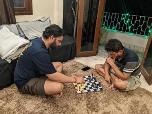 Dwóch mężczyzn siedzących na podłodze grających w szachy w obiekcie Guten Tag Kolkata w mieście Kolkata