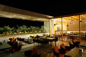a restaurant with tables and chairs and plants at Pride Biznotel Haldwani in Haldwāni
