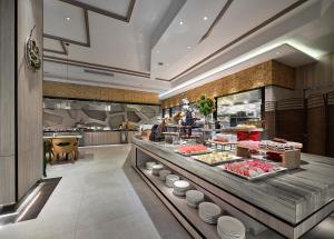 a buffet line in a restaurant with food on display at Vance Hotel - Taizhou in Taizhou