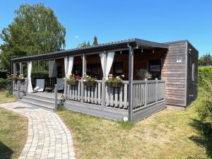a building with a porch with flowers on it at Exklusives Ferienhaus Rybak mit Boxspringbetten direkt am Steinhuder Meer in Wunstorf