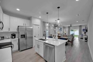 a kitchen with white cabinets and a kitchen with a dining room at SideB#JaxBeachRetreat w/Gameroom and BackyardOasis in Jacksonville Beach