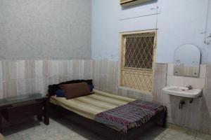 Dormitorio pequeño con cama y lavamanos en DK Hotel Singaraja, en Singaraja