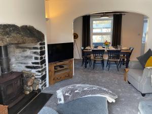 sala de estar con chimenea y mesa de comedor en 7 Castle Terrace, en Dolwyddelan
