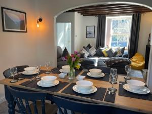 a dining room table with chairs and a living room at 7 Castle Terrace in Dolwyddelan