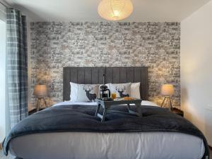 1 dormitorio con 1 cama grande y pared de ladrillo en 7 Castle Terrace, en Dolwyddelan