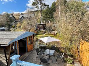 a patio with a table and chairs and an umbrella at 7 Castle Terrace in Dolwyddelan