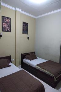 two beds in a small room with two at DK Hotel Singaraja in Singaraja