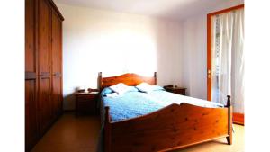 um quarto com uma cama de madeira e um edredão azul em Beachfront Condo Sea View - Airco - Covered Private Parking - Beach Place em Bibione