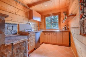 a large kitchen with wooden walls and a window at Osada Pod Turbaczem in Nowy Targ