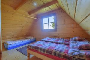 a bedroom with two beds in a log cabin at Osada Pod Turbaczem in Nowy Targ