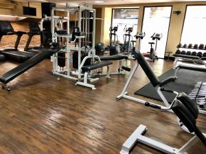 a gym with several treadmills and exercise machines at The Victory Residences Bangkok in Bangkok