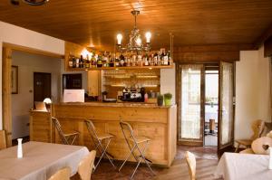 a restaurant with a bar with tables and chairs at Hotel Garni Edy in Daiano